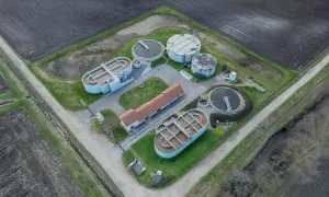 Widok z lotu ptaka na przepompownię ścieków domową z betonowymi zbiornikami i budynkiem.