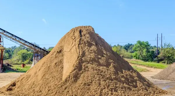 Ogromna hałda piasku na placu budowy. Zastanawiasz się, ile kosztuje tona piasku?