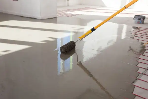 Wylewki anhydrytowe cena za 1m2. Wałek dociskowy rozprowadza świeżą masę, przygotowując podłogę pod ogrzewanie.