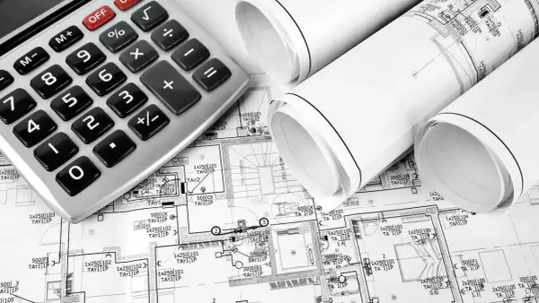 Kalkulator i projekty budowlane. Na planach widać oznaczenia punktów elektrycznych, co pozwala oszacować, ile kosztuje punkt elektryczny w zależności od jego typu i lokalizacji.