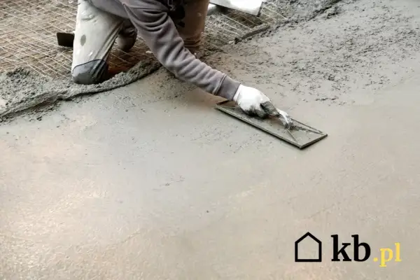 Ręczne zacieranie betonu kielnią, tworząc gładką powierzchnię. Praca na świeżym betonie.